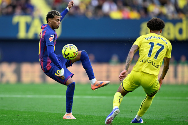 Pemain FC Barcelona Lamine Yamal berusaha melewati pemain Villarreal Tajon Buchanan pada pertandingan Liga Spanyol di Estadio de la Ceramica, Villarreal, Spanyol, Minggu (21/12/2025). Foto: Pablo Morano/REUTERS