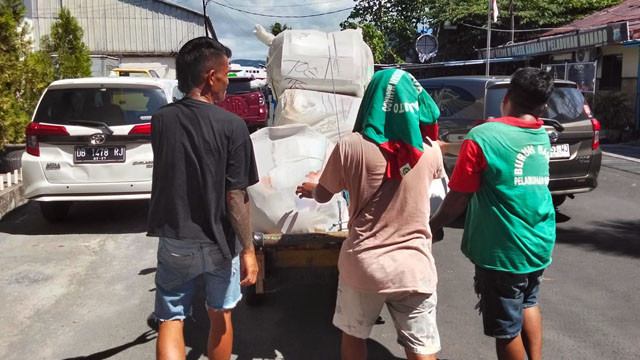Buruh angkut di pelabuhan Manado mengangkut barang milik penumpang kapal. 