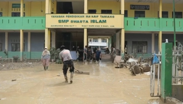Anggota Brimob dari Polda Aceh membersihkan sekolah yang terdampak banjir bandang di Kabupaten Aceh Tamiang, Aceh. Foto: Dok. Istimewa