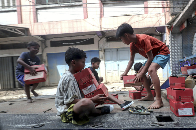 Sejumlah bocah mengangkat kerdus berisi bantun di Desa Kota Lintang Bawah, Kecamatan Kuala Simpang, Kabupaten Aceh Tamiang, Aceh, Senin (22/12/2025). Foto: Jamal Ramadhan/kumparan