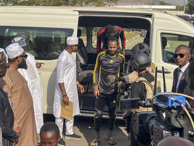 Anak-anak yang dibebaskan setelah diculik bulan lalu berjalan saat tiba di Kantor Pemerintahan Negara Bagian Niger di Minna, Senin (22/12/2025). Foto: Chenemi Bamaiyi/AFP