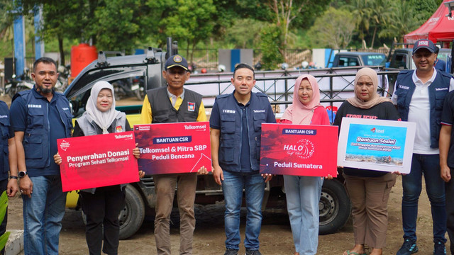 Vice President Consumer Business Area Sumatera Telkomsel, Saki Hamsat Bramono (tengah), saat menyalurkan bantuan pasca bencana banjir bandang di Kota Padang. Foto: Dok. Telkomsel