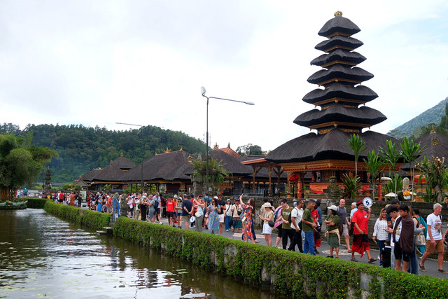 Wisatawan berjalan di dekat danau saat berkunjung di Daya Tarik Wisata (DTW) Ulun Danu Beratan, Tabanan, Bali, Rabu (24/12/2025). Foto: ANTARA FOTO/Nyoman Hendra Wibowo