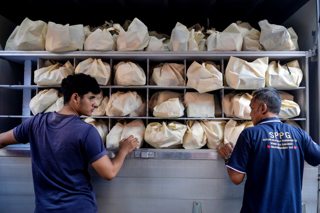 Petugas Satuan Pelayanan Pemenuhan Gizi (SPPG) bersiap mendistribusikan paket Makan Bergizi Gratis (MBG) di SDN Pabuaran Tumpeng 2, Kota Tangerang, Banten, Rabu (24/12/2025). Foto: ANTARA FOTO/Putra M. Akbar