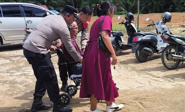 Polisi mendorong kursi roda warga yang hendak beribadah. Foto: Dok. Polres Sekadau