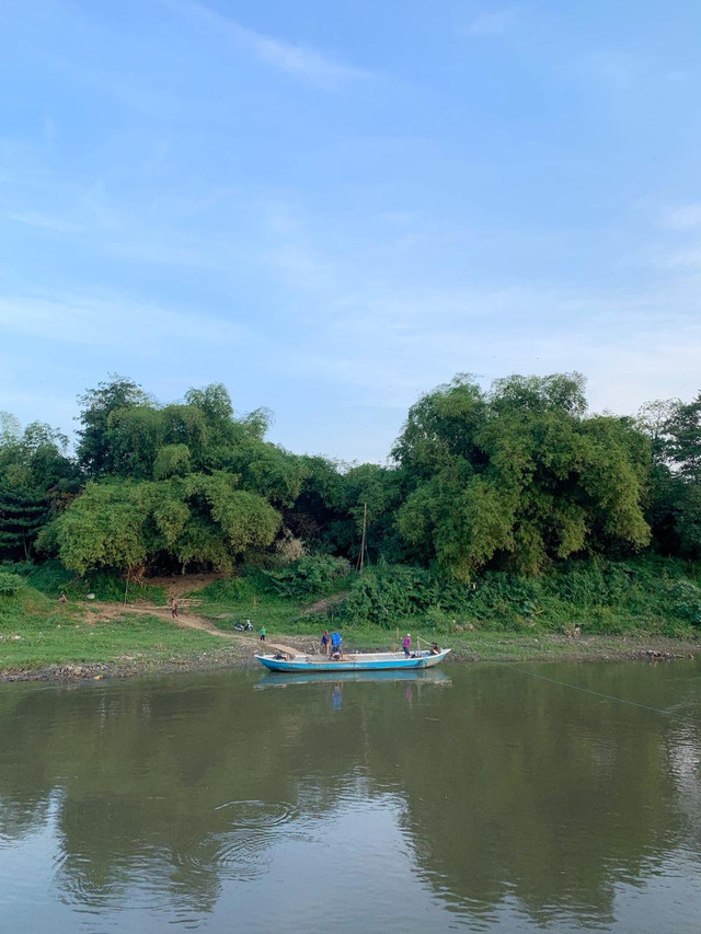 Perahu penyeberangan tradisional melintas tenang di Bengawan Solo, menjadi penghubung utama warga Sewu dan Gadingan. Foto : Dok. Pribadi