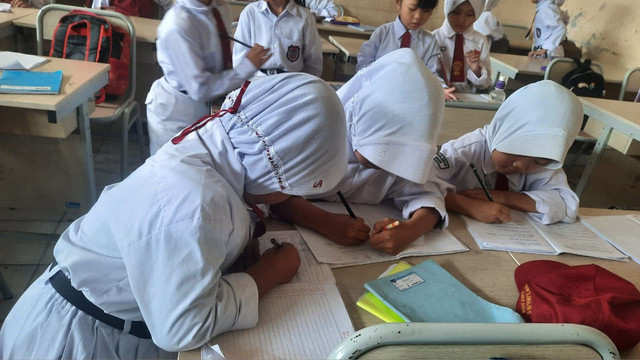 Anak sekolah sedang melakukan aktivitas belajar di kelas. (Sumber: Dokumentasi Pribadi)