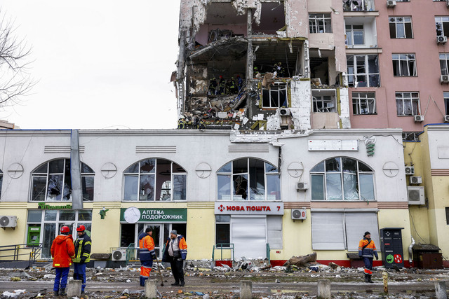 Pegawai pemerintah kota dan petugas pemadam kebakaran bekerja di lokasi gedung apartemen yang terkena serangan rudal dan drone Rusia di Kiev, Ukraina, Sabtu (27/12/2025). Foto: Valentyn Ogirenko/Reuters