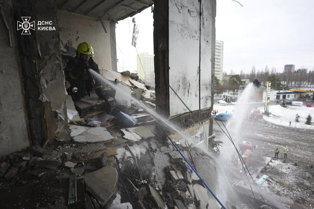 Petugas pemadam kebakaran memadamkan api yang membakar gedung apartemen yang terkena serangan rudal dan drone Rusia di Kiev, Ukraina, Sabtu (27/12/2025). Foto: State Emergency Service of Ukraine/Handout via REUTERS
