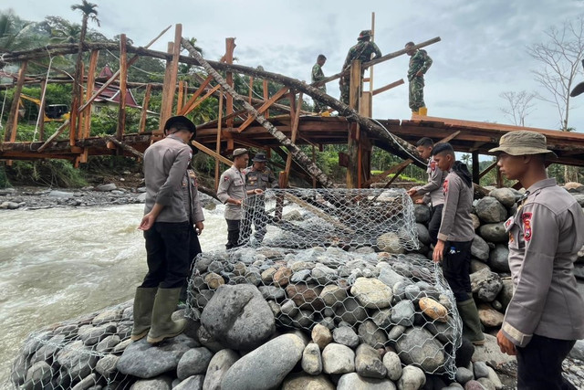 Personel TNI-Polri membangun jembatan darurat di Agam, Sumatera Barat. Foto: Bakom RI