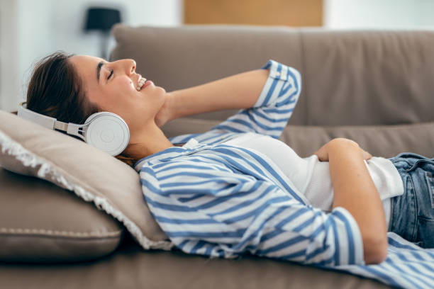 Sumber Gambar : https://media.istockphoto.com/id/1580684913/id/foto/wanita-cantik-bernyanyi-sambil-mendengarkan-musik-berbaring-di-sofa-di-ruang-tamu-di-rumah.jpg?s=612x612&w=0&k=20&c=B5mT_367k9bi0PtyH-lkKJCQduL5DQZ9wyJnRhM1C2s=