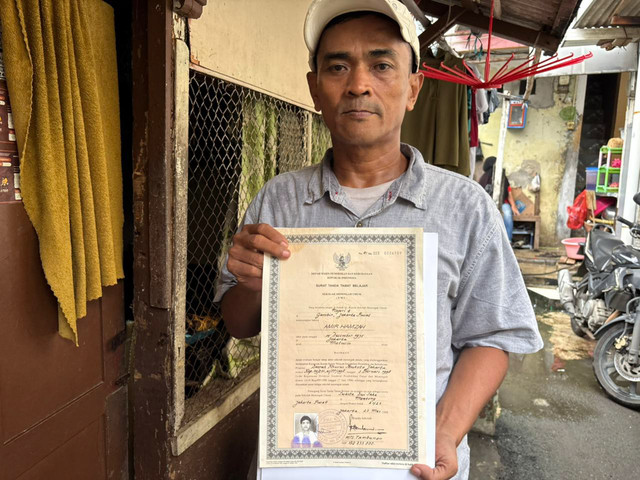 Amir Hamzah (50) memegang ijazahnya setelah diputihkan di rumahnya di kawasan Pegangsaan, Jakarta Pusat, Selasa (30/12/2025). Foto: Amira Nada Fauziyyah/kumparan