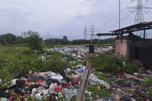 Tempat Pembuangan Sampah (TPS) ilegal yang berada di depan Perumahan Taman Kebalen, Kecamatan Babelan, Kabupaten Bekasi, usai ditutup kondisinya sepi, Rabu (31/12/2025). Foto: kumparan