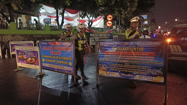 Satlantas Polres Cianjur menutup dan mengalihkan arus kendaraan yang mengarah kawasan wisata Puncak, Cipanas, Cianjur, Jawa Barat, pada malam Tahun Baru 2026, Rabu (31/12/2025). Foto: Dok. kumparan