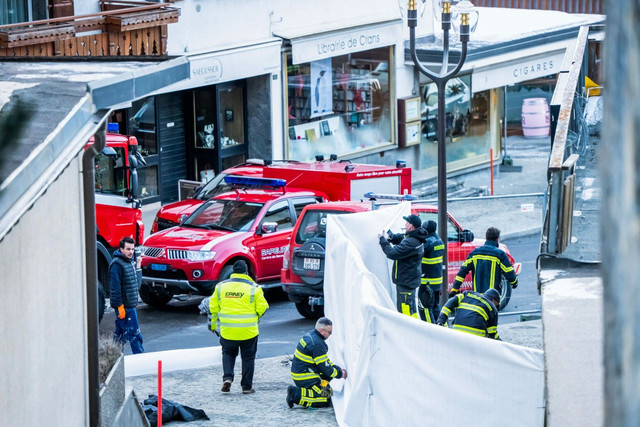 Sejumlah petugas terlihat terlihat di lokasi ledakan sebuah bar di Crans-Montana, Swiss, pada Kamis (1/1/2026) Foto: MAXIME SCHMID/AFP