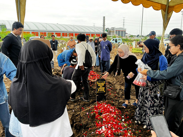 Sejumlah warga mengunjungi dan menaburi bunga di makam tiga anggota keluarga yang tewas di TPU Rorotan, Jakarta Utara, Sabtu (3/1/2026). Foto: Rayyan/Kumparan