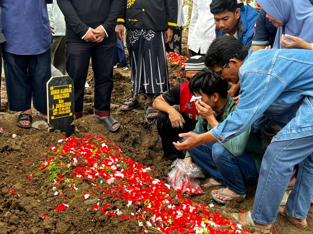 Khadafi menangis saat di Makam keluarganya yang meninggal di kontrakan di TPU Rorotan, Jakarta Utara, Jakarta Utara, Sabtu (3/1/2026). Foto: Rayyan/Kumparan
