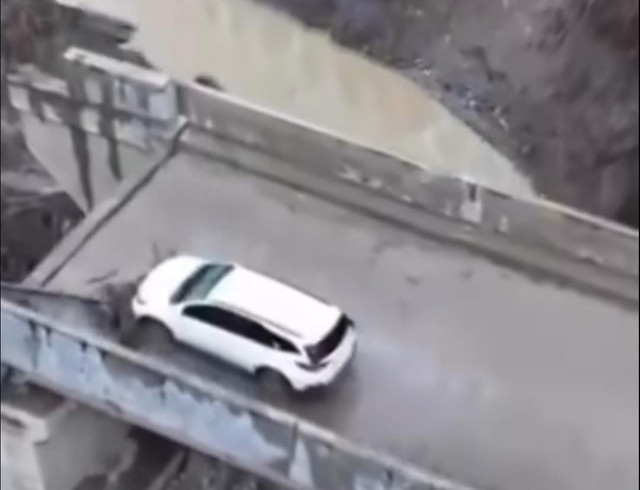 Mobil Camat Pantan Cuaca terjebak di atas jembatan akibat luapan Sungai Tripe setelah hujan lebat mengguyur wilayah Gayo Lues. Foto: Dok. BPBD Gayo Lues