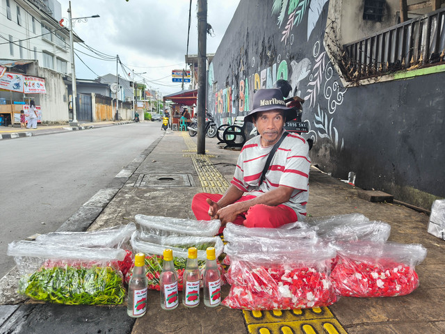 Bambang dan bunga dagangannya di trotoar Jalan Sulaiman, Kebon Jeruk, Jakarta Barat, Sabtu (3/1/2026). Foto: Jeni Ritanti/kumparan