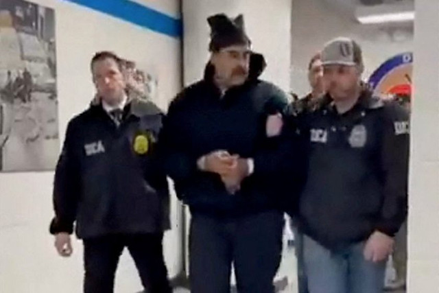 Presiden Venezuela Nicolas Maduro (tengah) digiring dalam tahanan menyusuri lorong di kantor Badan Penegakan Narkoba AS (DEA) di New York City, AS, Sabtu (3/1/2026). Foto: @RapidResponse47/HO via REUTERS