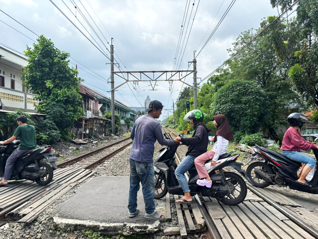 Indra (55), penjaga palang kereta api di perlintasan sekitar Stasiun Tebet, Jakarta Selatan, Minggu (4/1/2026). Foto: Amira Nada/kumparan