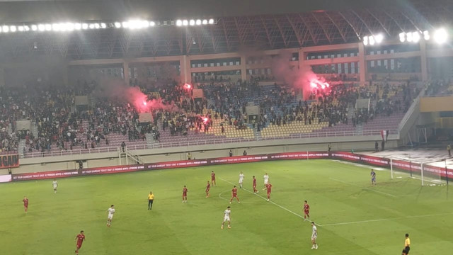 Suporter nyalakan flare di tengah laga Persis Solo melawan Persita Tangerang pada pertandingan Super League di Stadion Manahan, Solo, Minggu (4/1/2025). Foto: kumparan