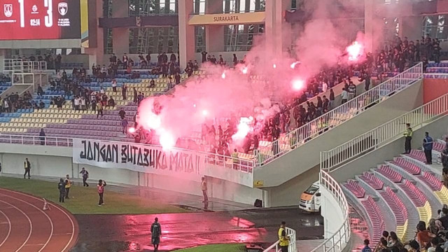 Suporter nyalakan flare di tengah laga Persis Solo melawan Persita Tangerang pada pertandingan Super League di Stadion Manahan, Solo, Minggu (4/1/2025). Foto: kumparan