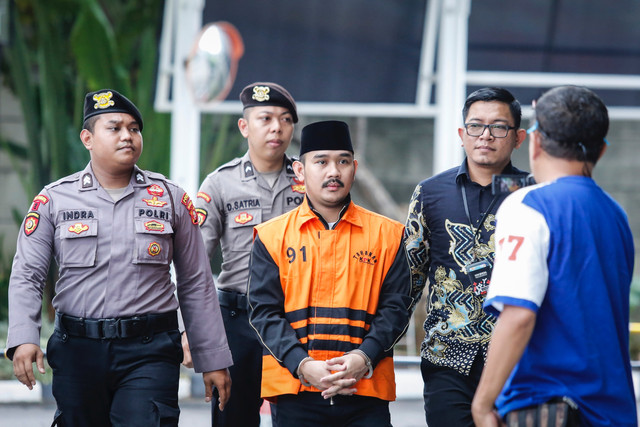 Tersangka kasus dugaan tindak pidana korupsi terkait suap ijon proyek di Kabupaten Bekasi Ade Kuswara Kunang (tengah) berjalan menuju ruang pemeriksaan di Gedung Merah Putih KPK, Jakarta, Selasa (6/1/2026). Foto: Asprilla Dwi Adha/ANTARA FOTO