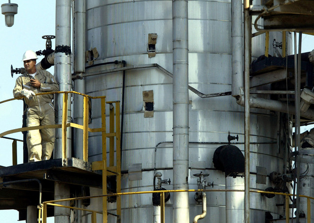 Seorang pekerja minyak Venezuela dari perusahaan negara PDVSA berpartisipasi dalam pengisian tanker minyak di terminal pengiriman dan penyimpanan Jose, 200 mil sebelah timur Caracas, Venezuela. Foto: Jorge Silva/REUTERS