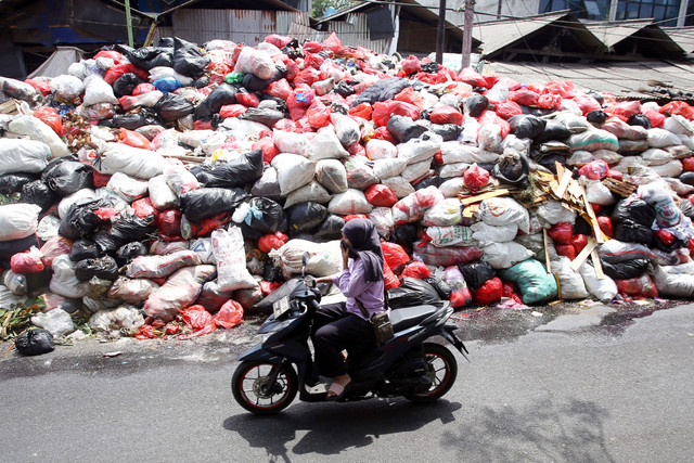 Pengendara melintas di samping gunungan sampah yang ada di Jalan Raya Otista, Cimanggis, Tangerang Selatan, Banten, Selasa (6/1/2026). Foto: Muhammad Iqbal/ANTARA FOTO