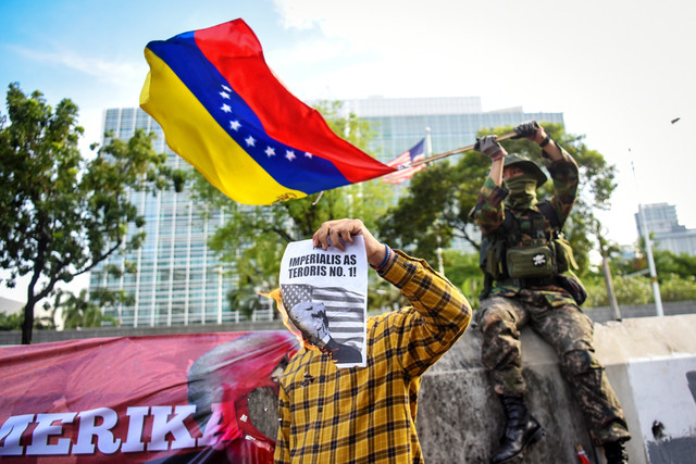 Pengunjuk rasa dari aliansi buruh dan pegiat kemanusiaan mengibarkan bendera Venezuela dan membakar poster presiden AS Donald Trump saat menggelar aksi solidaritas untuk Venezuela di depan Kedutaan Besar Amerika Serikat, Jakarta, Selasa (6/1/2026). Foto: Indrianto Eko Suwarso/ANTARA FOTO