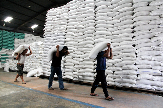 Tiga pekerja memikul karung beras di Gudang Bulog Pulo Brayan, Medan, Sumatera Utara, Selasa (6/1/2026). Foto: Yudi Manar/ ANTARA FOTO
