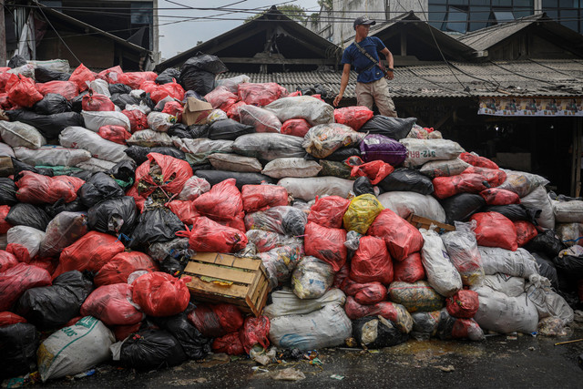 Petugas pasar Cimanggis menata tumpukan sampah yang terus meninggi di kawasan Tangerang Selatan, Rabu (7/1). Foto: Aditia Noviansyah/kumparan