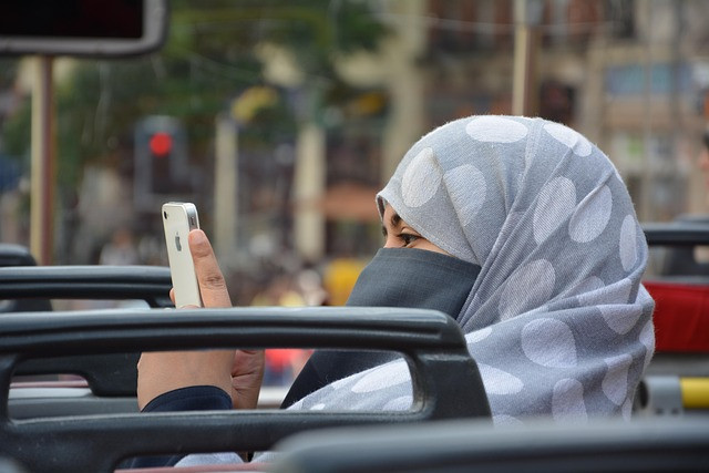 Seorang muslimah sedang memainkan HP foto by Pixabay