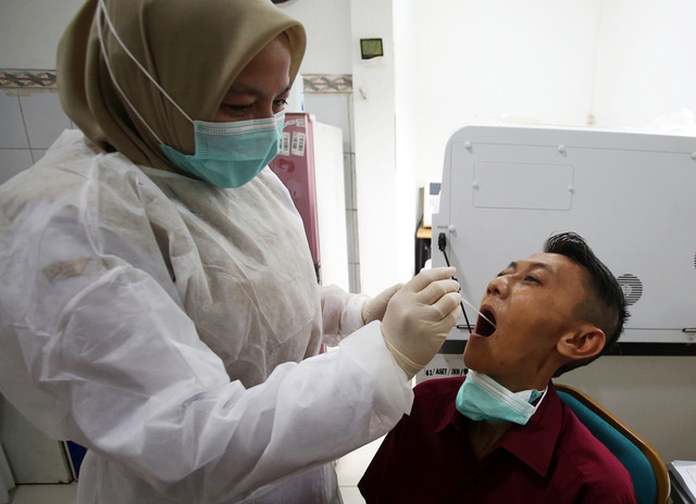 Tenaga kesehatan melakukan tes usap atau swab test pasien saat penapisan gejala influenza di Puskesmas Serpong 1, Serpong, Tangerang Selatan, Banten, Rabu (7/1/2026). Foto: Muhammad Iqbal/kumparan