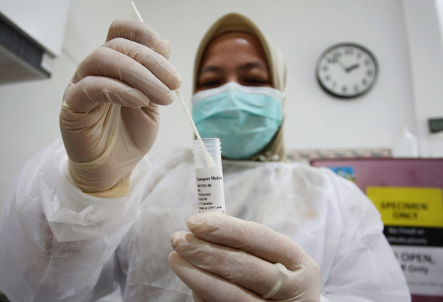 Tenaga kesehatan menaruh spesimen ke dalam tabung kecil untuk dikirim ke laboratorium usai melakukan tes usap atau swab test pasien saat penapisan gejala influenza di Puskesmas Serpong 1, Serpong, Tangerang Selatan, Banten, Rabu (7/1/2026). Foto: Muhammad Iqbal/kumparan
