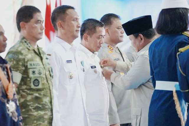 Presiden Prabowo Subianto menyematkan tanda kehormatan Satyalancana Wira Karya kepada Bupati Karawang Aep Syaepuloh saat panen raya dan pengumuman swasembada pangan nasional 2025 di Cilebar, Karawang, Jawa Barat, Rabu (7/1/2026). Foto: Dok. Istimewa