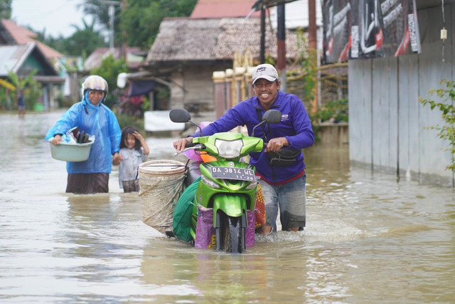 Warga mendorong motor saat menerobos banjir di Banjar, Kalimantan Selatan, Rabu (7/1/2026). Foto: kumparan
