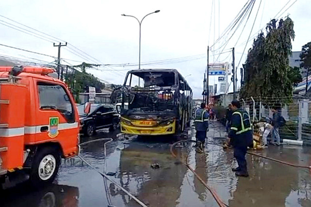 Petugas pemadam kebakaran telah mematikan api yang melahap Bus lintas Lampung-Bekasi saat melintas di Jalan Diponegoro, Tambun Selatan, Kabupaten Bekasi, Sabtu (10/1/2026). Foto: Dok. Istimewa