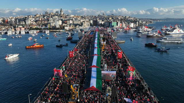 Ribuan massa aksi memadati Jembatan Galata, Istanbul, sambil mengibarkan bendera Palestina berukuran besar yang membentang di tengah jembatan.