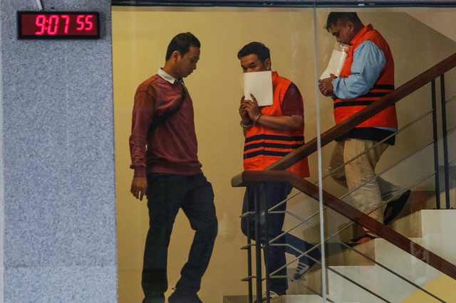 Kepala KPP Madya Jakarta Utara Dwi Budi (kanan) bersama Tim Penilai di KPP Madya Jakarta Utara Askob Bahtiar (tengah) menuruni tangga sembari menggunakan rompi tahanan usai menjalani pemeriksaan di Gedung Merah Putih KPK, Jakarta, Minggu (11/1/2026). Foto: Asprilla Dwi Adha/ANTARA FOTO