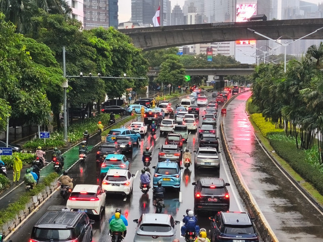 Lalu lintas di kawasan Sudirman, Jakarta tersendat akibat diguyur hujan deras pada Senin pagi (12/1). Foto: Jeni Ritanti/kumparan