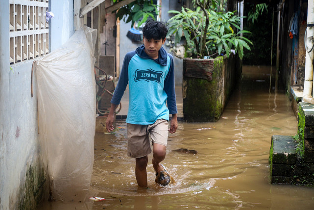 Warga berjalan melawati banjir di Cilandak Timur, Pasar Minggu, Jakarta Selatan, Senin (12/1/2026). Foto: Iqbal Firdaus/kumparan
