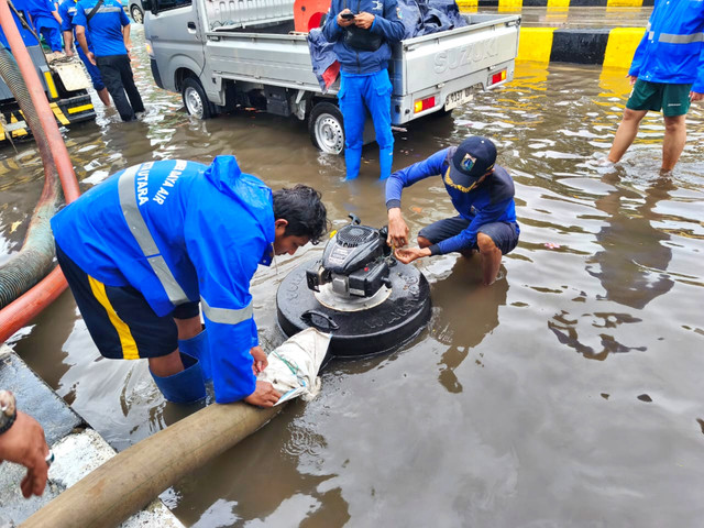 Petugas Suku Dinas Sumber Daya Air DKI Jakarta menangani genangan air di Jalan Gunung Sahari, Jakarta Utara, Selasa (13/1/2026). Foto: Jeni Ritanti/kumparan