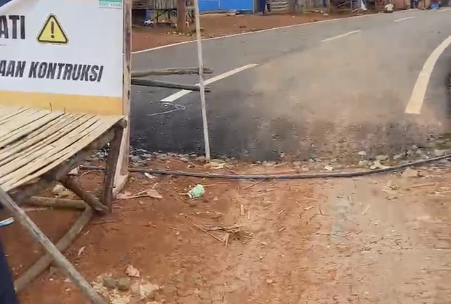 Jalan beraspal di Jabar dengan jalan tanah di Banten, di perbatasan Jabar-Banten, Kecamatan Lebak, Banten. Dok: Muhammad Zaenudin