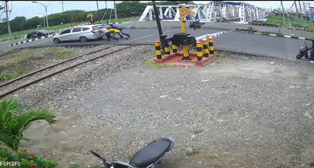 Kabid Humas Polda Jateng Kombes Artanto dan warga saat mendorong mobil yang mogok di lintasan kereta api. Foto: Dok Istimewa