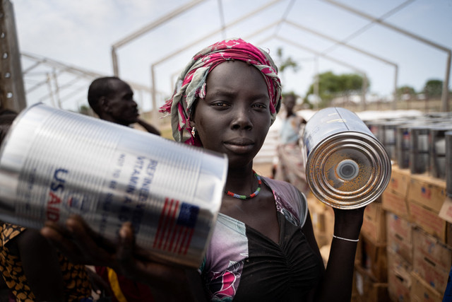 Seorang wanita dari kelompok etnis Murle menerima kaleng minyak selama distribusi makanan oleh Program Pangan Dunia Perserikatan Bangsa-Bangsa (WFP) di Gumuruk, Sudan Selatan, pada 10 Juni 2021. Foto: Simon Wohlfahrt / AFP