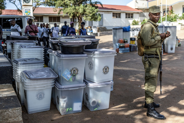 Polisi Uganda menjaga kotak suara dan material pemilu lainnya untuk dikirim di sebuah tempat pemungutan suara di Kampala, Uganda, Rabu (14/1/2026). Foto: LUIS TATO / AFP