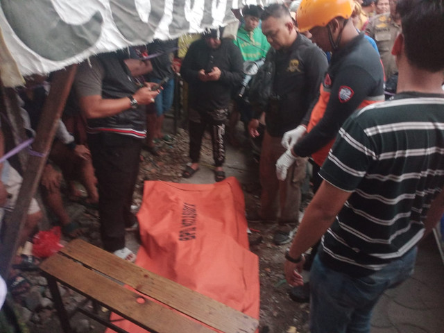 Petugas mengevakuasi pria tanpa identitas tewas bersimbah darah di bahu Jalan Wonokusumo Jaya, Kecamatan Semampir, Surabaya Minggu (18/1/2026). Foto: Dok. BPBD Surabaya