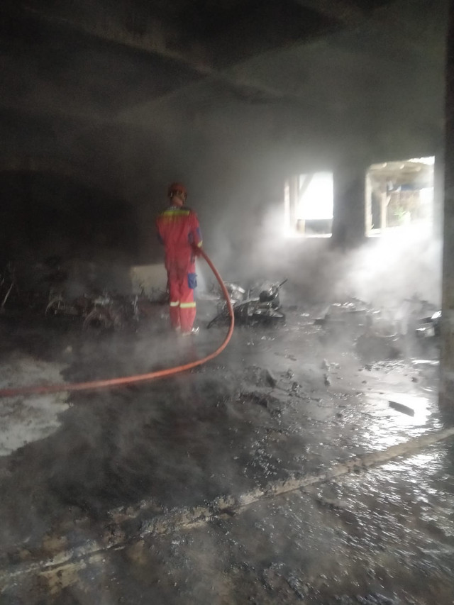 Petugas pemadam mendingankan lokasi kebakaran yang melanda tempat penitipan motor Wahyu Motor yang berada di sekitar kawasan Stasiun Bogor, Senin (19/1) pukul 06.00 WIB. Foto: Damkar Kota Bogor